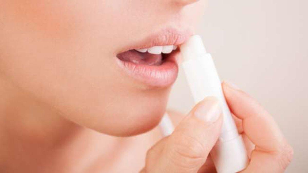 Ilustrasi wanita mengaplikasikan lip balm.