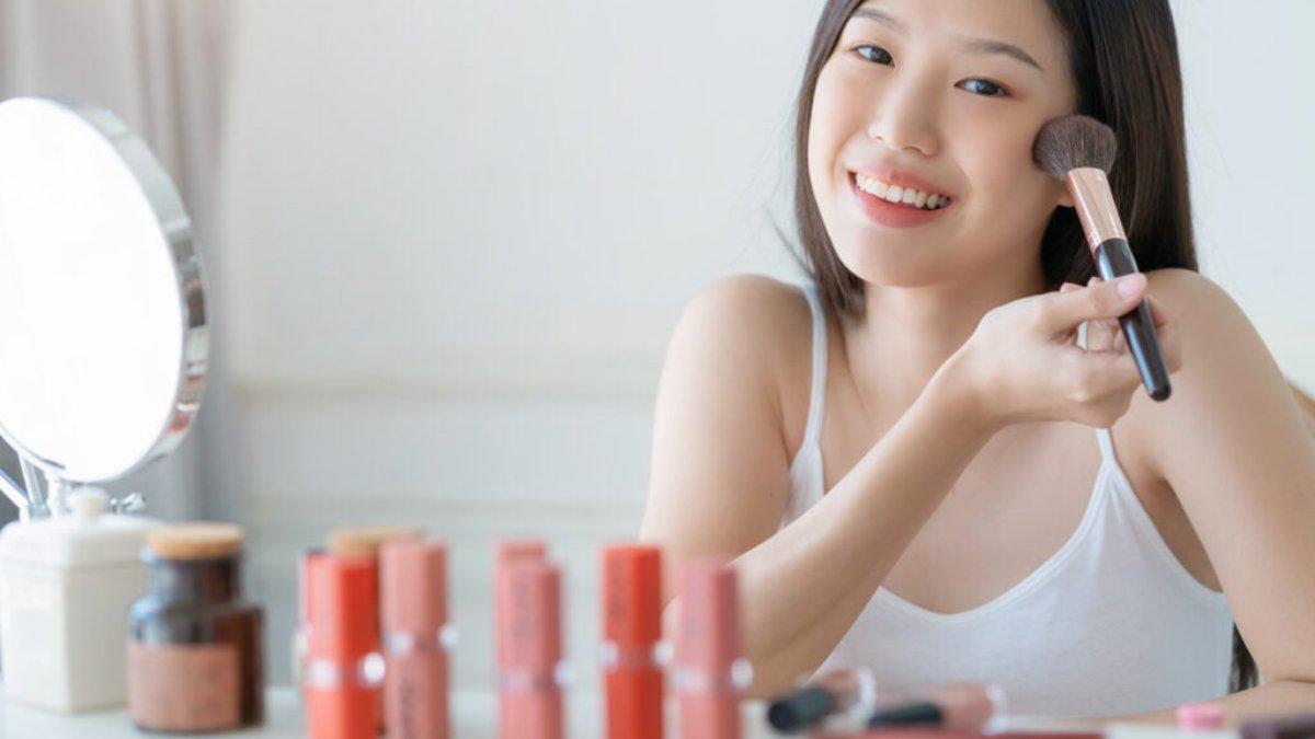 Ilustrasi wanita menggunakan cream blush.
