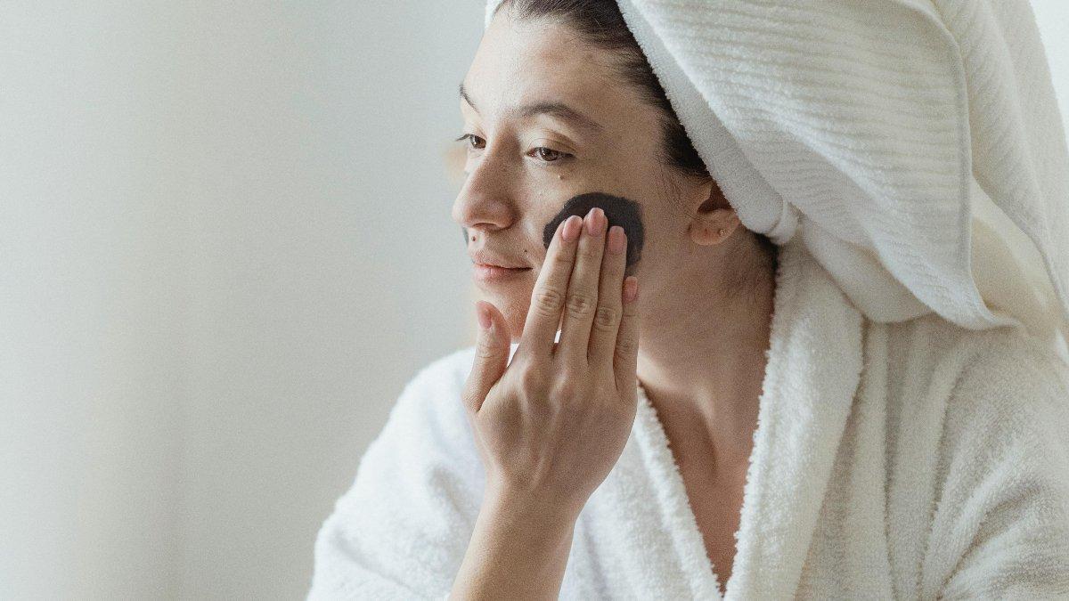 Ilustrasi wanita menggunakan hydrating toner setelah mencuci wajah.