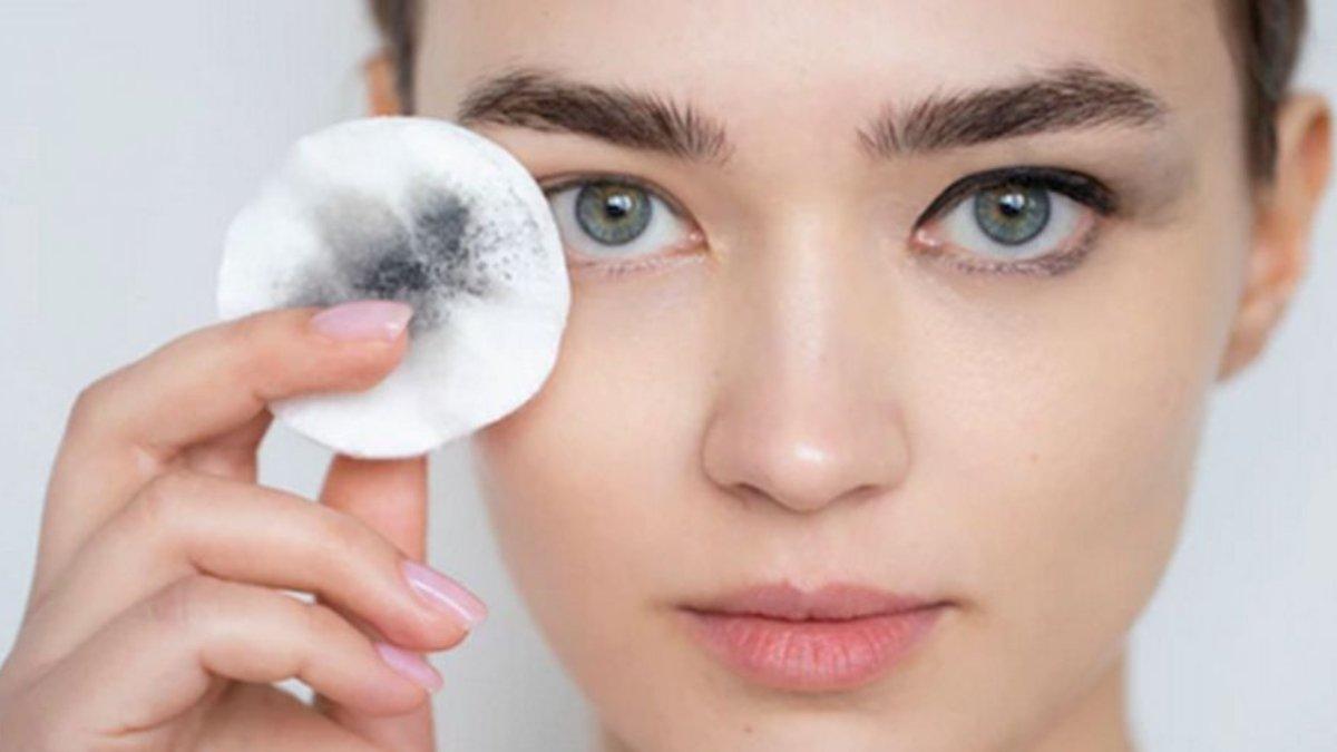 Ilustrasi wanita menghapus sisa makeup mata menggunakan micellar water.