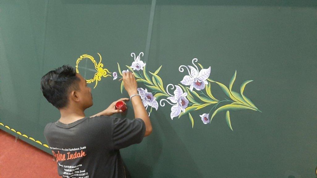 Seorang pelukis Nasrafa sedang melukis motif bunga untuk bahan hijab/jilbab. (Tribunshopping.com)