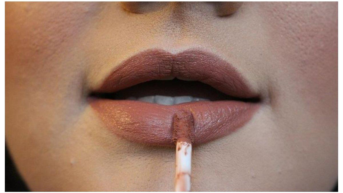 Mengaplikasikan produk lip cream.