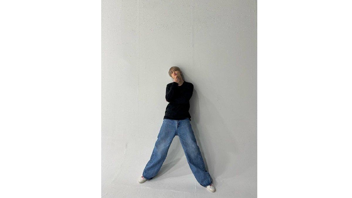 Padu Padan Outfit Denim ala Jaehyun NCT mengenakan Longsleeve Crewneck dengan Baggy Jeans dan White Sneaker.