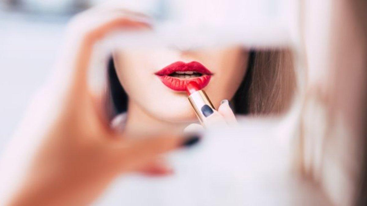 Ilustrasi wanita mengaplikasikan lipstik yang punya kandungan pelembap.