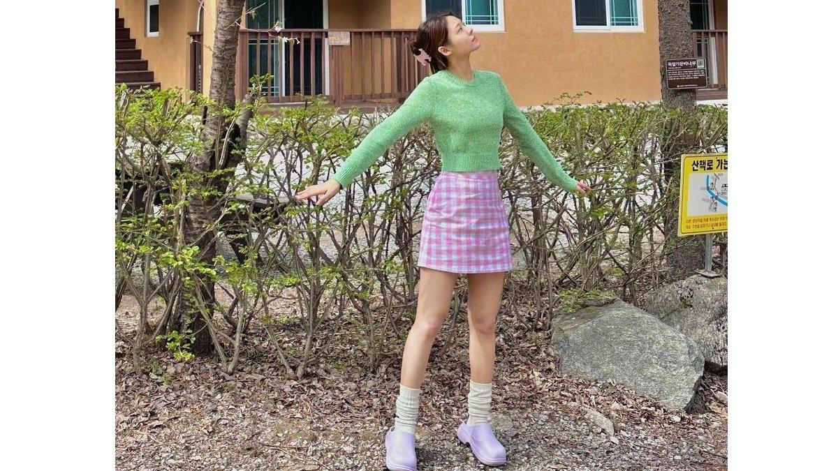 Seolhyun Tampil dengan Sweater Hijau dan Rok Mini Motif.