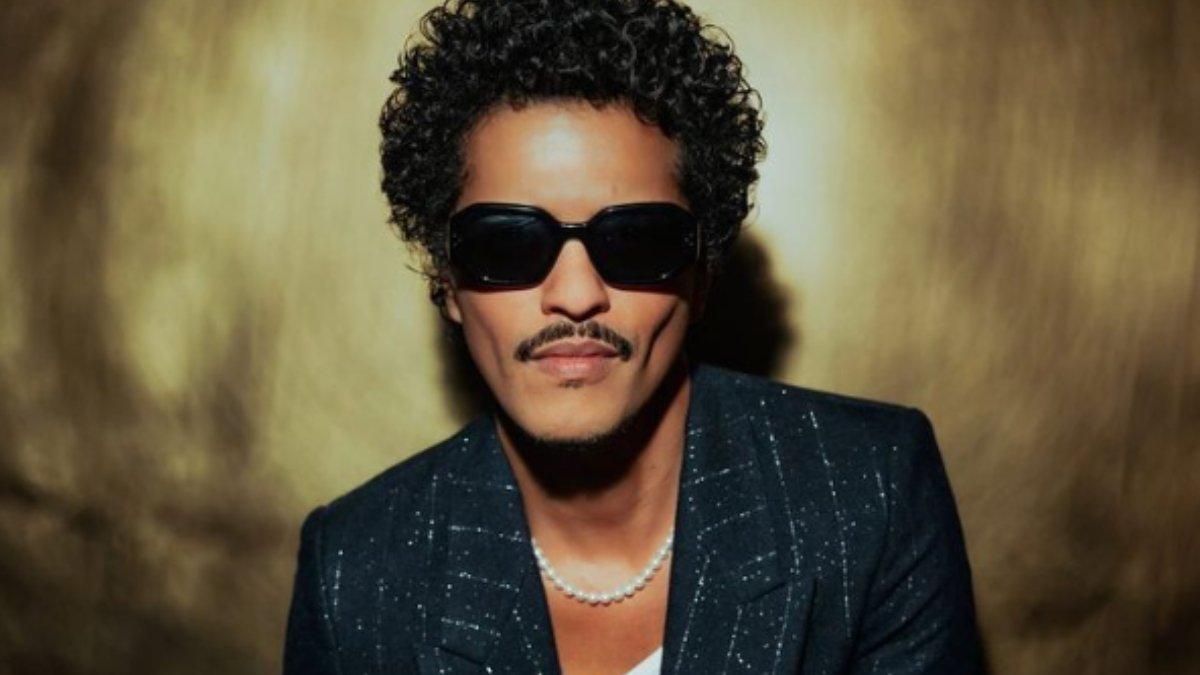 Style Bruno Mars yang glamor dengan berbagai perhiasan.