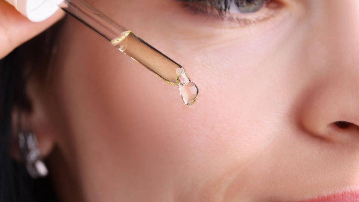 Ilustrasi wanita menggunakan face oil.