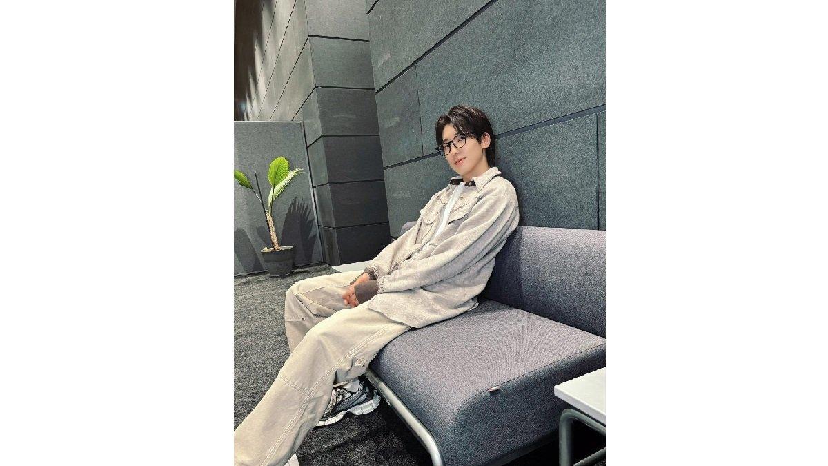 Wonwoo Seventeen mengenakan Kaus Putih, Zip Jaket dengan Celana Kargo dan Sneakers.