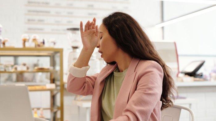 Wanita yang bersin-bersin karena alergi udara dingin.