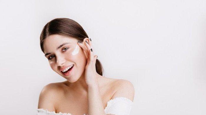 Ilustrasi wanita menggunakan sunscreen di wajah.