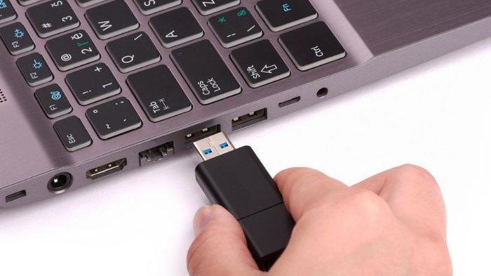 Ilustrasi memasang flashdisk ke port USB laptop