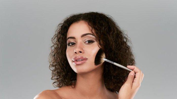 Ilustrasi wanita menggunakan highlighter di wajah.
