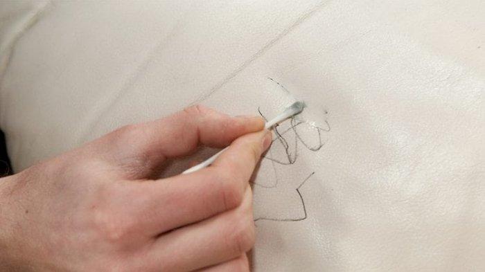 Ilustrasi coretan pulpen di permukaan sofa kulit dan sulit untuk dibersihkan.