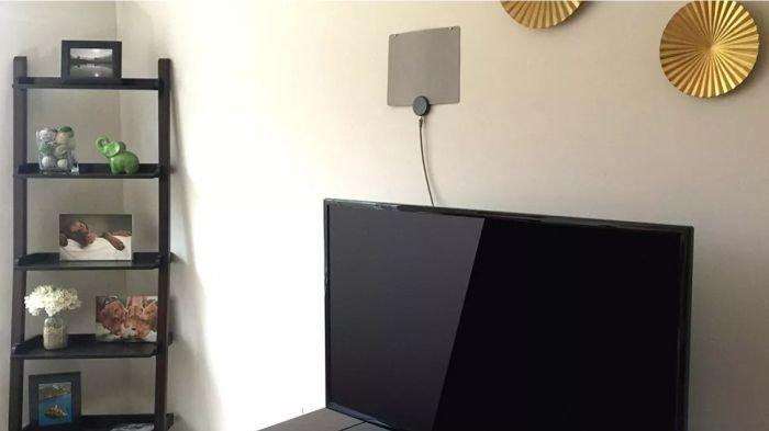 Ilustrasi antena TV Digital yang dipasang lebih tinggi, tertempel di dinding rumah