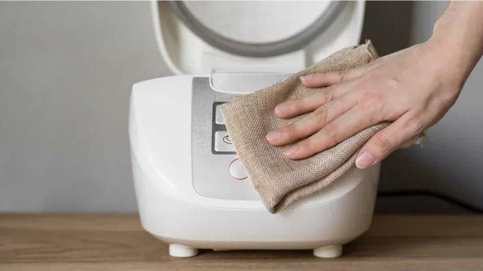 Ilustrasi mengelap rice cooker agar tidak basah sebelum dipakai