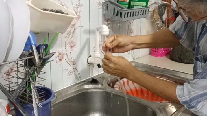 Ilustrasi mengalirkan air keran untuk membilas selang gas LPG