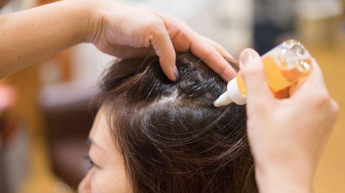 Ilustrasi mengaplikasikan produk hair tonic untuk merawat rambut.