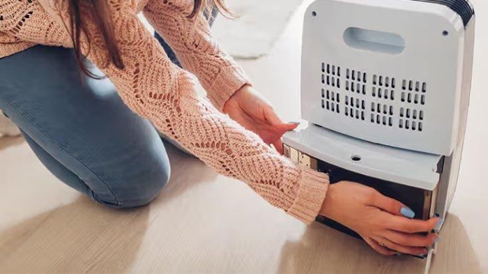 Ilustrasi penggunaan dehumidifier untuk menyerap kelembapan berlebih di dalam rumah.