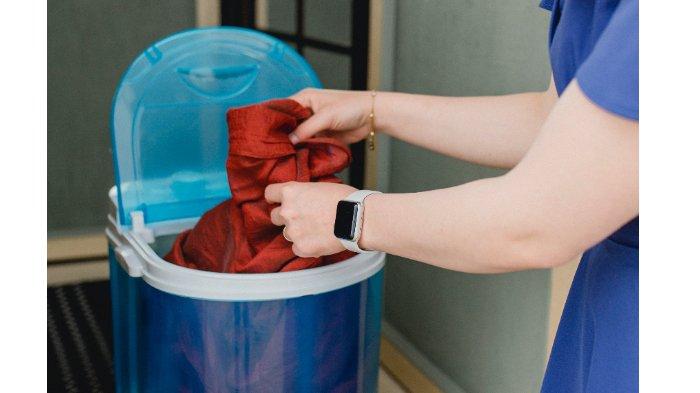 Ilustrasi penggunaan mesin cuci portable untuk kemudahan membersihkan pakaian di mana saja