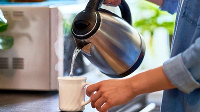 Ilustrasi menuangkan air panas dari teko listrik