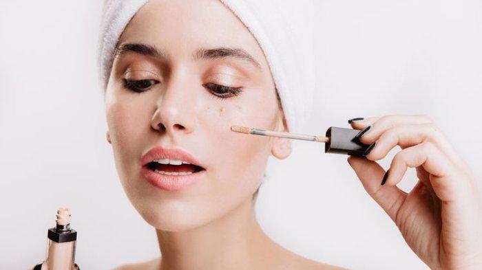 Ilustrasi seorang wanita mengaplikasikan concealer untuk menyempurnakan tampilan make up di wajah.