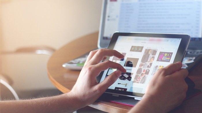 Ilustrasi seseorang sedang browsing atau mencari informasi di internet pakai tablet