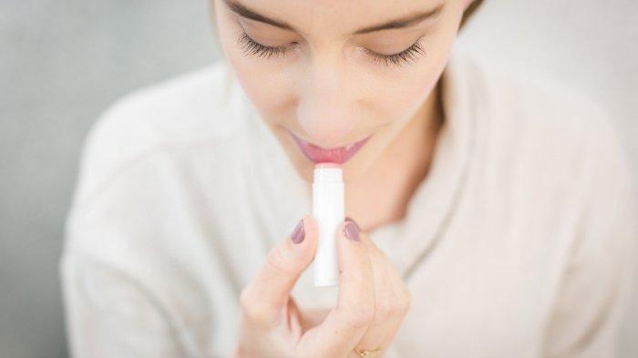 Ilustrasi wanita mengaplikasikan lip balm.