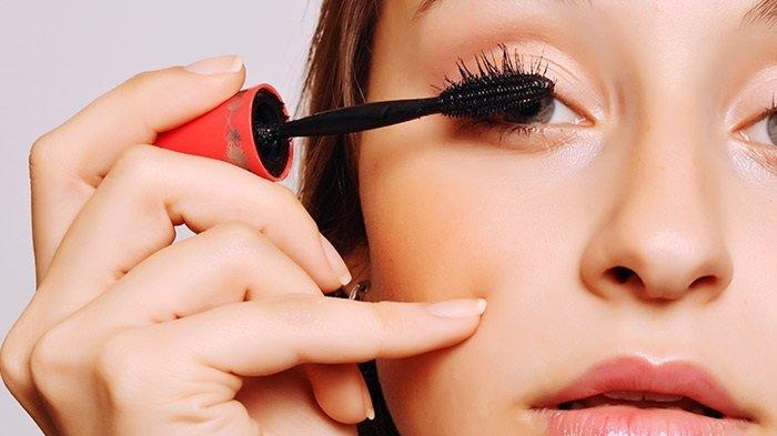 Ilustrasi wanita mengaplikasikan maskara.