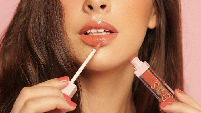Ilustrasi wanita menggunakan lip gloss.
