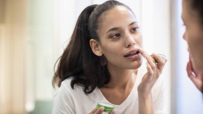 Ilustrasi wanita melakukan perawatan bibir.