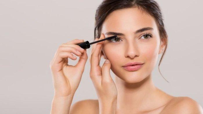 Ilustrasi wanita sedang mengaplikasikan maskara.