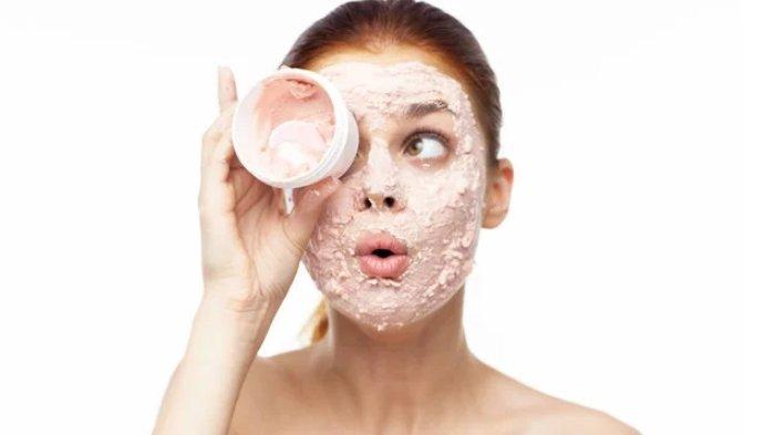 Ilustrasi seorang wanita melakukan eksfoliasi kulit dengan produk terbaik.