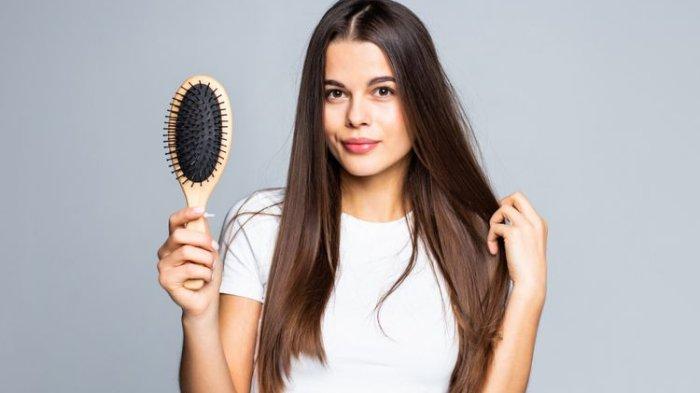 Ilustrasi seorang wanita menyisir rambut sebelum mandi keramas.