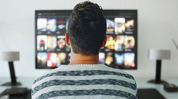 Ilustrasi seorang pria sedang menonton televisi dengan Android TV di rumah