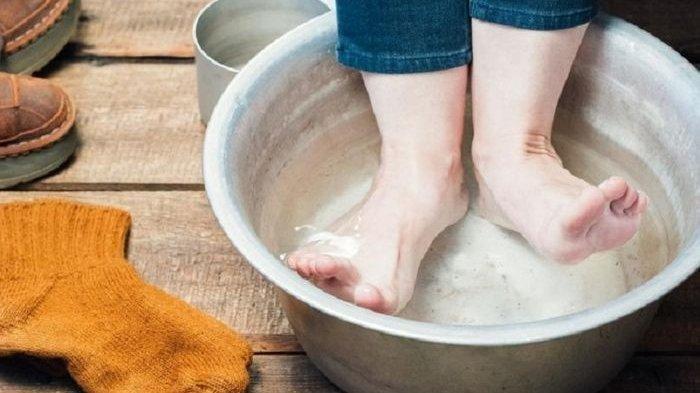 Merendam kaki dengan air garam.