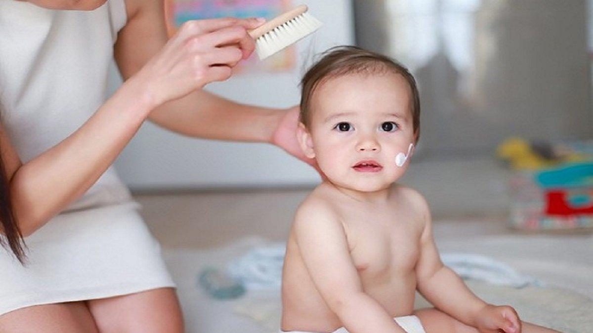 Ilustrasi bunda menggunakan produk penumbuh rambut bayi untuk si kecil.