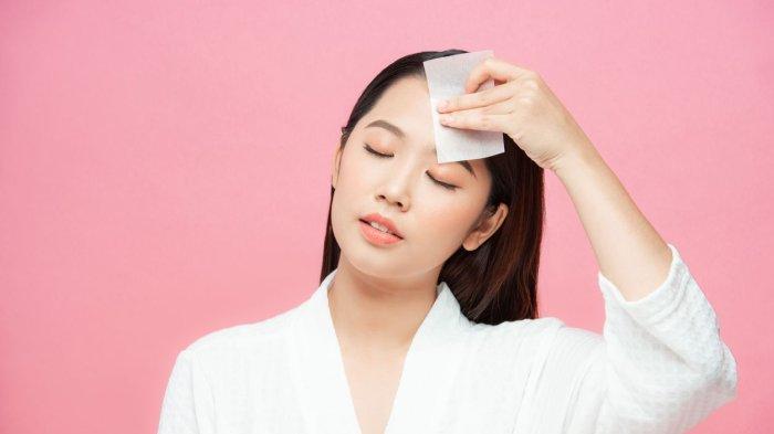 Ilustrasi seorang wanita yang merasa terganggu karena kulit wajah terlalu berminyak.