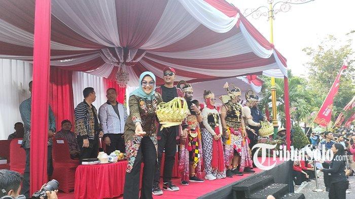 Bupati Klaten, Sri Mulyani menyebarkan apem kepada masyarakat yang hadir di Karnaval Budaya Kabupaten Klaten tahun 2023, Sabtu (19/8/2023).