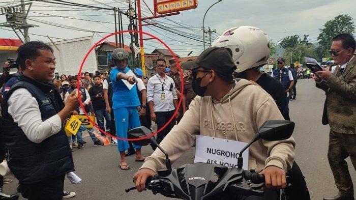 REKA ADEGAN. Aipda Robig Zaenudin (38) memperagakan dirinya saat menembak tiga pelajar SMKN 4 Semarang masing-masing Gamma atau GRO (17), SA (17) dan AD (16) di depan Alfamart Jalan Candi Penataran Raya, Ngaliyan, Kota Semarang, Senin (30/12/2024).