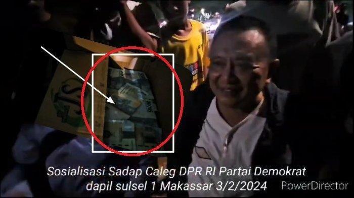 Caleg DPR RI Dapil Sulsel I, Syarifuddin Daeng Punna, bagi-bagi uang kepada masyarakat di Anjungan Pantai Losari (Panlos) Makassar, Sulawesi Selatan (Sulsel), baru-baru ini
