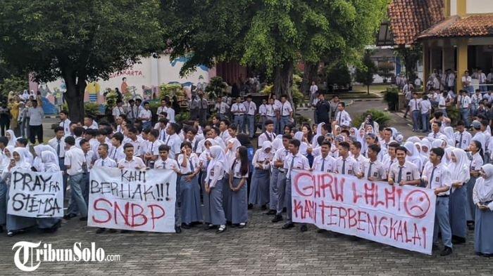 SISWA DEMO SEKOLAHNYA SENDIRI : Ratusan siswa kelas XII Sekolah Menengah Kejuruan Negeri (SMKN) 2 Solo ditemani wali murid gelar aksi demo di halaman sekolah, Senin (3/2/2025) siang. Keterlambatan pengisian data pendaftaran PPDS mengancam para siswa yang duduk di bangku kelas XII SMKN 2 Solo tak bisa masuk ke perguruan tinggi lewat jalur prestasi.