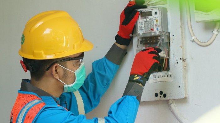 PELAYANAN MASYARAKAT. Petugas dari PLN memperbaiki kWh Meter atau sering disebut dengan Meteran Listrik.