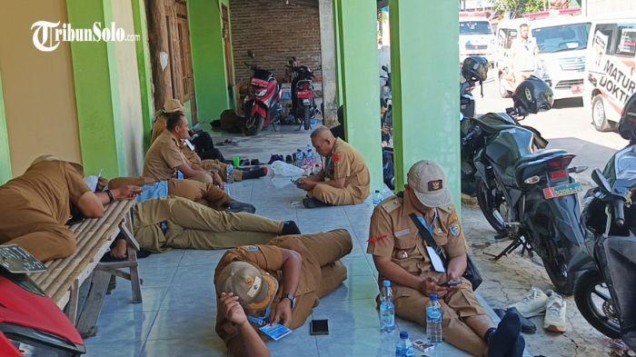 NGEMPER - Puluhan kepala desa (kades) yang hadir dari berbagai daerah tampak kelelahan menunggu kedatangan Presiden Prabowo Subianto di Desa Bentangan, Kecamatan Wonosari Klaten, Senin (21/7/2025). Mereka terlihat duduk hingga tidur di lantai dan teras bangunan sekitar lokasi acara.