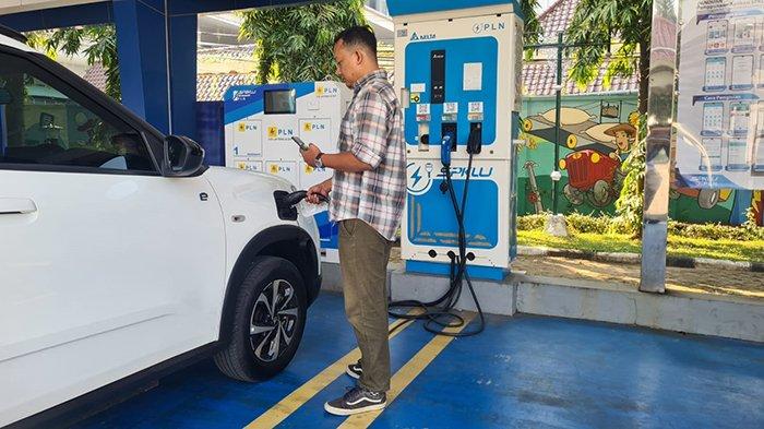 Pengendara mobil listrik mengisi daya kendaraan listrik di SPKLU PLN dengan PLN Mobile