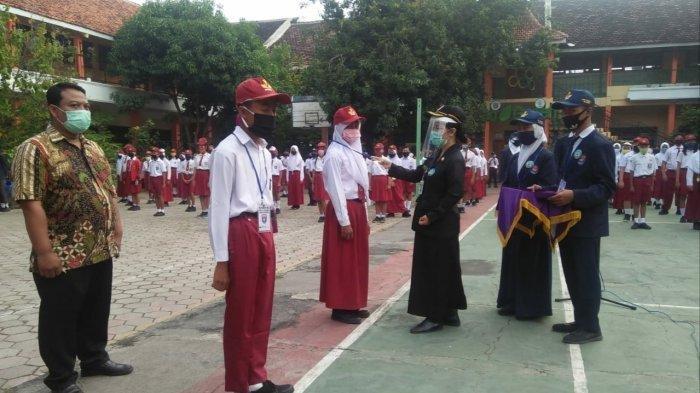 Kepala SMPN 4 Sragen, Nining Kristanti ketika menyematkan tanda MPLS kepada siswa, Senin (13/7/2020)