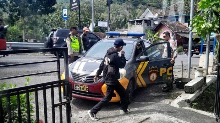 TERNYATA SEHAT: Seorang penulis surat berisi pengakuan dirinya telah melompat dari jembatan Kretek yakni OIB, warga Sleman, berjalan di depan mobil Polsek Kretek, Senin (9/6/2025). Ia ditemukan sehat di warung soto.