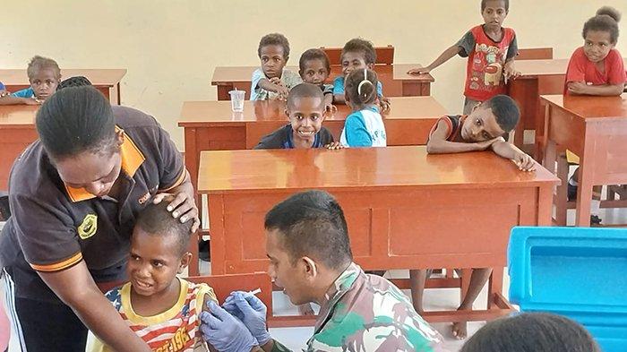Satgas Yonif 133/YS menyuntikkan imunisasi ke seorang anak SD di Kabupaten Maybrat, Kamis (7/12/2023).