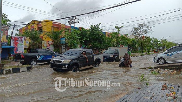 Sejumlah pengendara nekat menerobos banjir di depan perempatan mall Jupiter, Jalan Sungai Maruni, KM 10, Kota Sorong, Papua Barat Daya, Senin (22/1/2024).