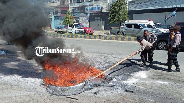 Jajaran Polresta Sorong Kota membongkar palang dan pembakaran ban di dua titik ruas jalan Kota Sorong, Papua Barat Daya, Sabtu (21/9/2024). (tribunsorong.com/safwan)