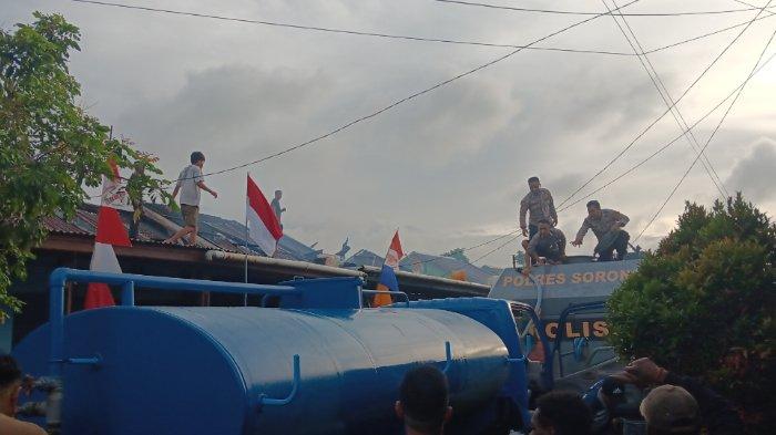 Petugas damkar bersama masyarakat memadamkan api di KPR Cenderawasih Blok F Aimas Kabupaten Sorong.